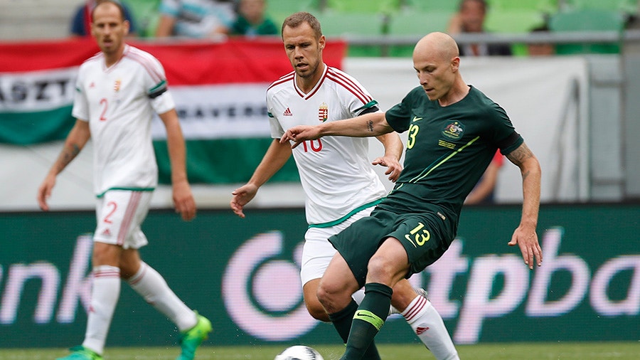 Aaron Mooy of Australia passes the ball next to Krisztian Vadocz of Hungary before Janos Szabo of Hungary.