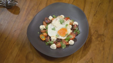 Fried egg, black bean and tomato salad, and goats cheese cream