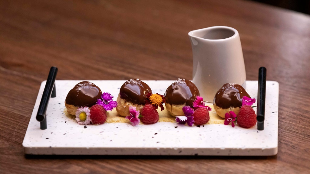 Dark Chocolate Profiteroles, Hazelnut Praline Crumb and Raspberry Coulis