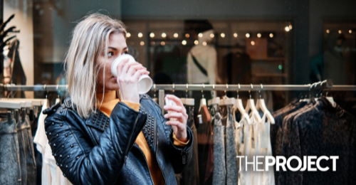 Woman drinking coffee outside a store